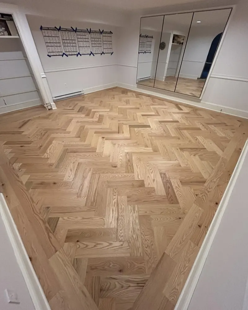 An oak herringbone floor laid tight across a room.
