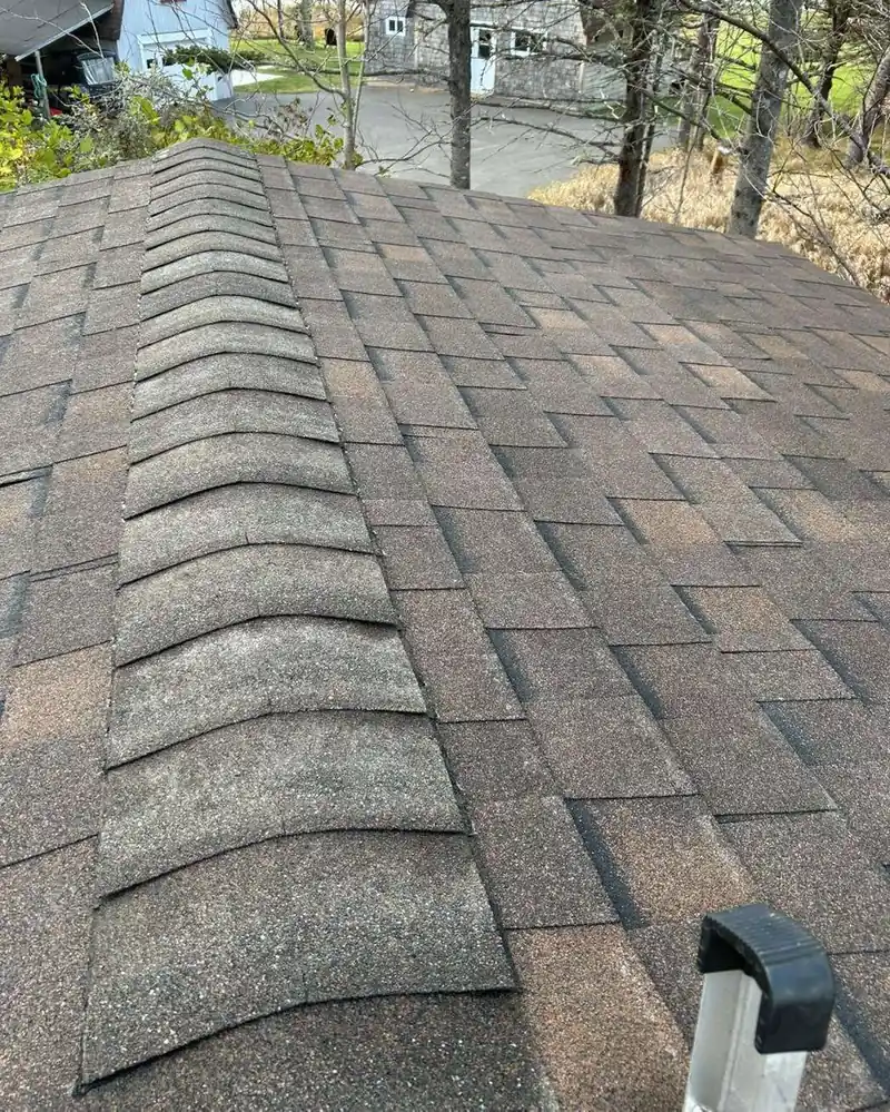 A newly shingled roof with the ridge cap run out along the peak.