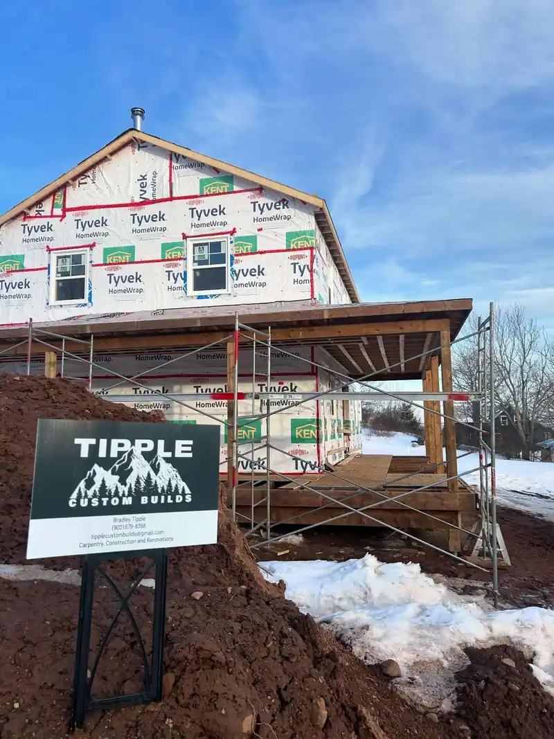 A Tipple Custom Builds site board in front of a house under staging.